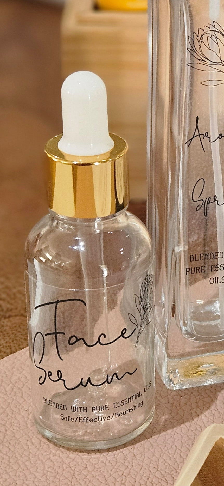 Clear skincare serum bottle with dropper and wooden scoop on a textured surface