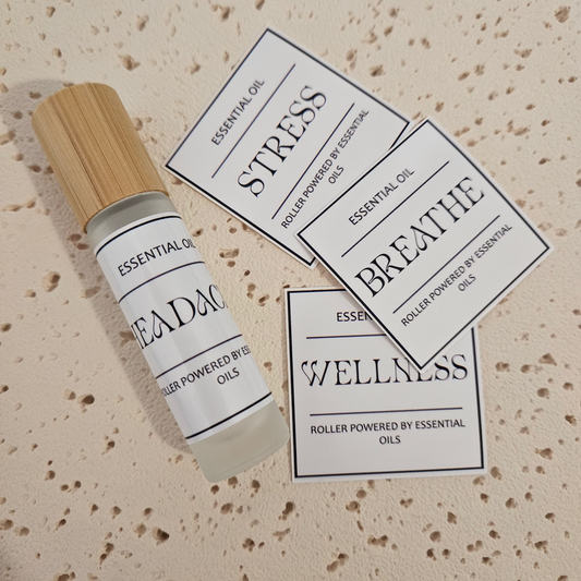 Essential oil roller 10ml bottle with wooden cap.  Bold text essential oil labeled 'Stress', 'Breathe', and 'Wellness'.
