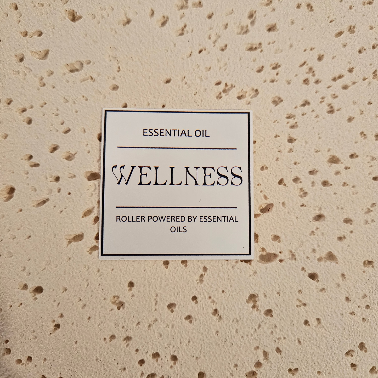  'Wellness' essential oil roller packaging label. Bold text