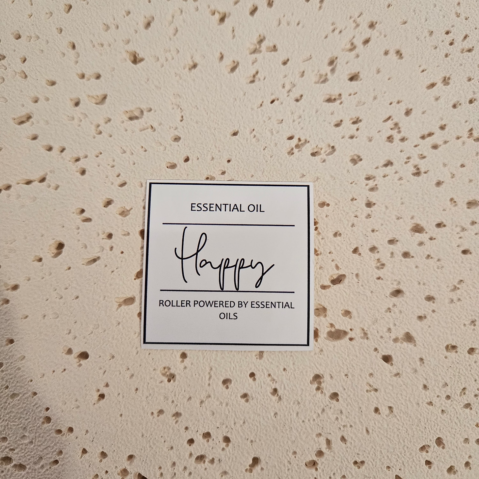 Essential oil roller bottle labelled 'Happy' in script writing
